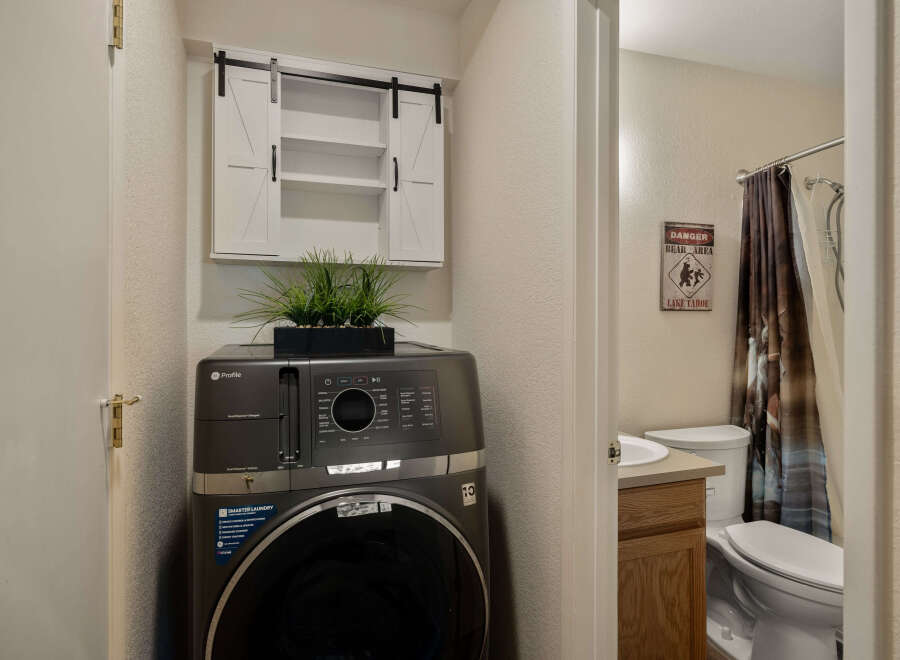 This charming property features a convenient laundry area with a modern GE Profile washer and dryer, complemented by stylish storage.
