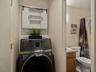 This charming property features a convenient laundry area with a modern GE Profile washer and dryer, complemented by stylish storage.