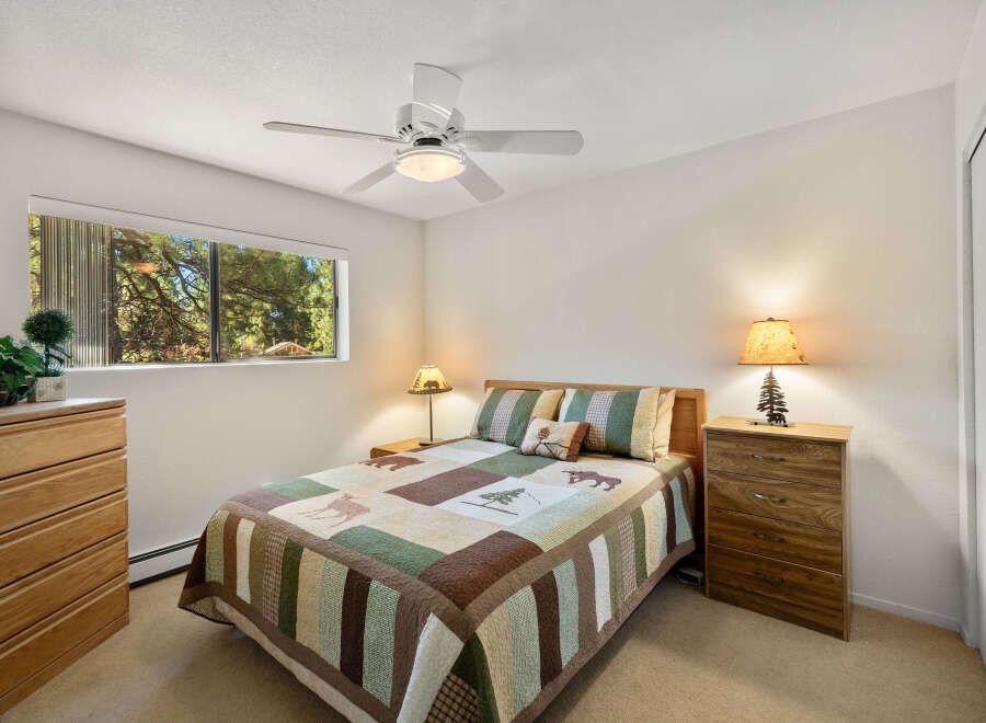 This cozy bedroom features a comfortable bed with a rustic quilt and matching pillows, perfect for a relaxing retreat.