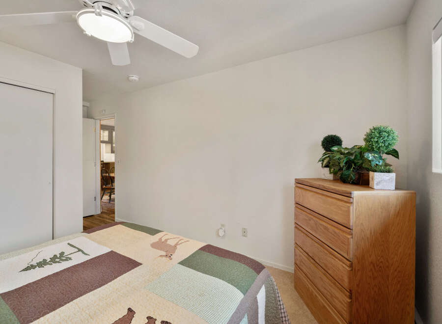 This cozy bedroom features a comfortable bed with a unique quilt, perfect for a relaxing night's sleep.