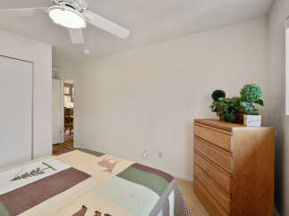 This cozy bedroom features a comfortable bed with a unique quilt, perfect for a relaxing night's sleep.
