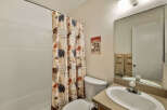 This charming bathroom features a rustic shower curtain with nature-themed designs, creating a cozy and inviting atmosphere.