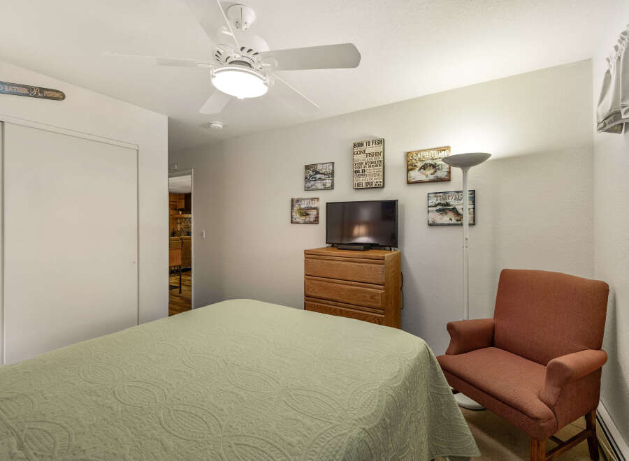 This cozy bedroom features a comfortable bed with a patterned quilt, perfect for a relaxing night's sleep.
