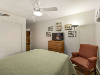 This cozy bedroom features a comfortable bed with a patterned quilt, perfect for a relaxing night's sleep.