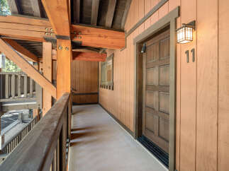 This charming property features a beautifully designed exterior with wooden accents and a welcoming entrance.