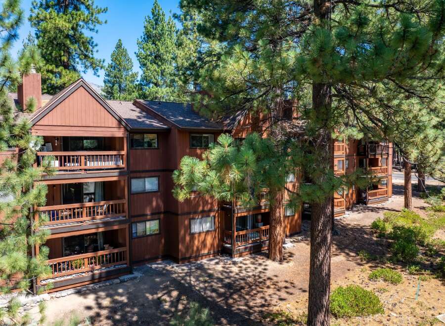 Nestled amidst lush greenery, this stunning property boasts a warm, inviting exterior with multiple levels of balconies.