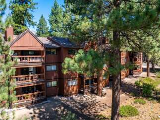 Nestled amidst lush greenery, this stunning property boasts a warm, inviting exterior with multiple levels of balconies.