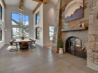 Experience luxury living in this stunning property featuring a grand stone fireplace, perfect for cozy evenings.
