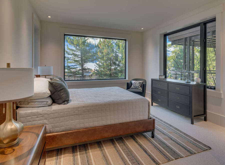Experience luxury living in this stunning bedroom with breathtaking mountain views.