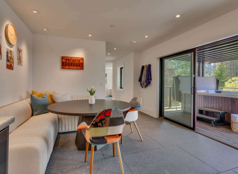 This stunning property boasts a modern dining area with a round table and unique patchwork chairs, perfect for entertaining.