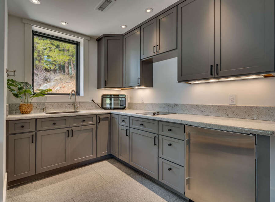 This modern kitchen boasts sleek gray cabinetry and a stunning granite countertop, creating a sophisticated and functional space.