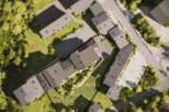 This aerial view showcases a modern apartment complex nestled in a serene, green environment.