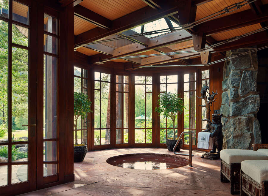 This luxurious spa room features a stunning design with a natural stone pillar and a built-in hot tub.