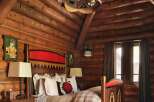 Step into rustic elegance in this stunning log cabin bedroom.