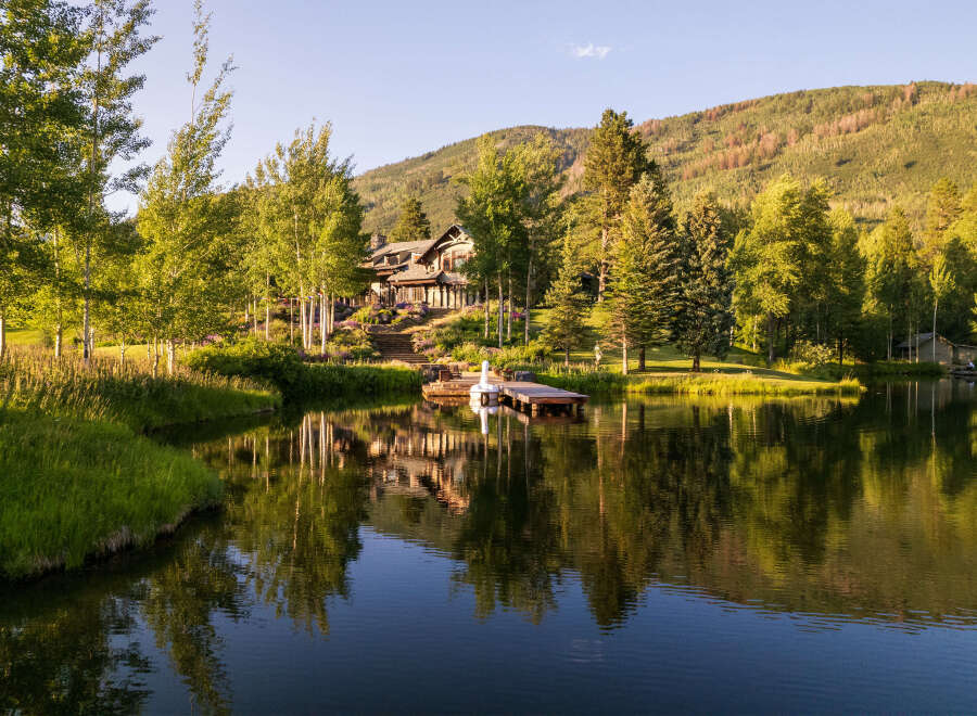 This stunning property boasts a luxurious house nestled beside a serene lake, offering breathtaking views of the surrounding mountains.