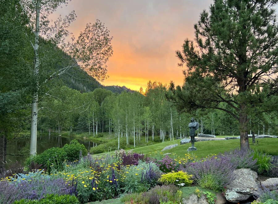 Experience the tranquility of this stunning property, featuring lush landscaping and a serene pond.