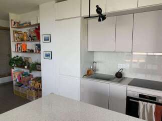 This modern kitchen boasts sleek, white cabinetry and a minimalist design, perfect for contemporary living.