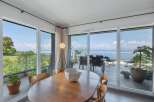 Experience breathtaking views from this stunning property, featuring expansive windows that frame the serene water and lush greenery.