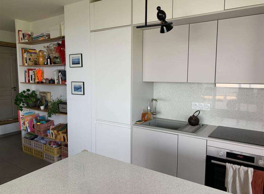 This modern kitchen boasts sleek, white cabinetry and a minimalist design, perfect for contemporary living.
