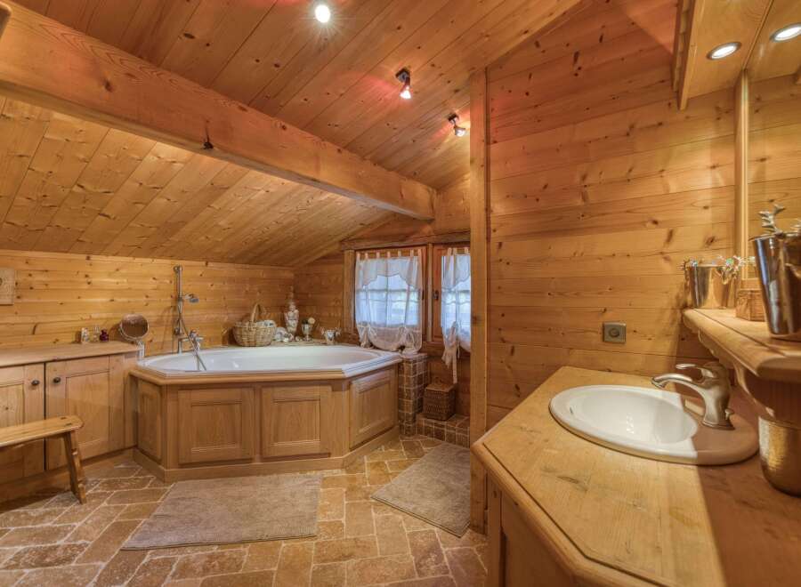 This charming bathroom features a warm, inviting ambiance with its wooden paneling and natural light.