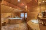 This charming bathroom features a warm, inviting ambiance with its wooden paneling and natural light.