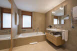 This luxurious bathroom features a modern design with a sleek bathtub, a stylish vanity, and a large mirror.