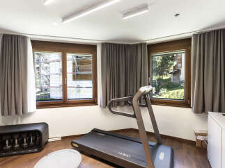 This home gym offers a bright and airy space for workouts, featuring a modern treadmill and ample natural light.
