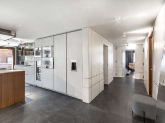 This modern kitchen boasts sleek, white cabinetry and integrated appliances, creating a seamless and stylish design.