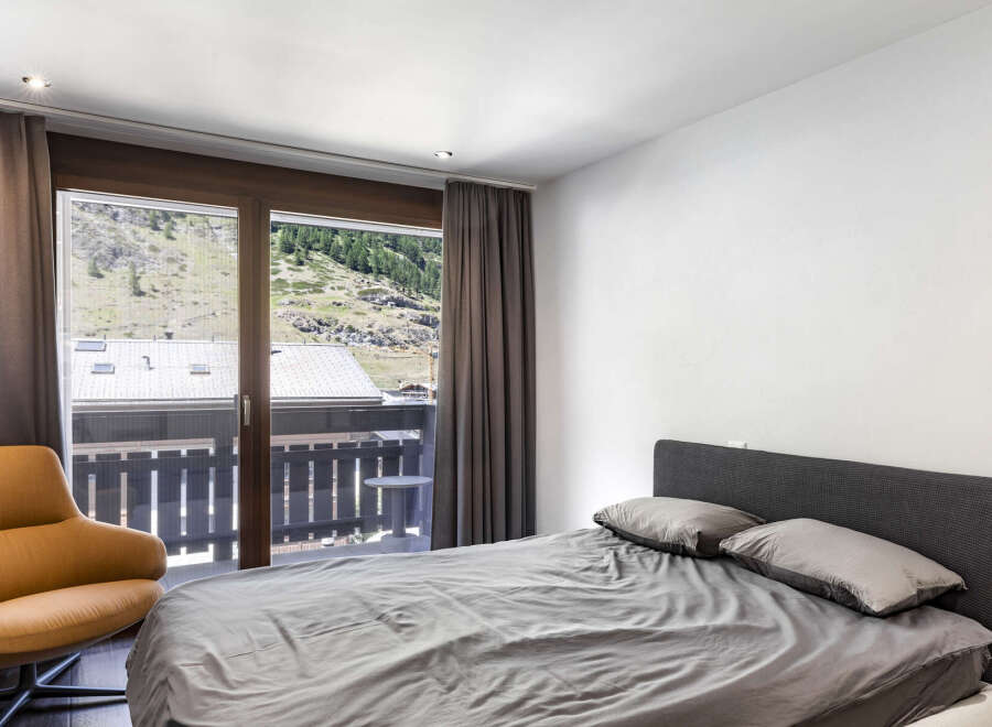 This bedroom offers stunning views of the surrounding landscape through large windows.