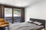 This bedroom offers stunning views of the surrounding landscape through large windows.