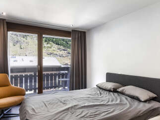 This bedroom offers stunning views of the surrounding landscape through large windows.