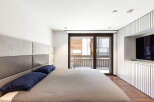 This modern bedroom features a stylish design with a comfortable bed and a sleek built-in TV.