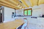 This stunning kitchen boasts a modern design with sleek white cabinetry and a warm wooden ceiling.
