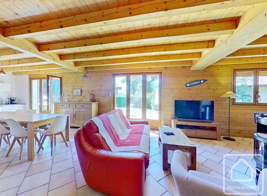 This charming property boasts a warm and inviting interior with exposed wooden beams and paneling, creating a cozy atmosphere.