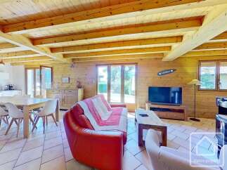 This charming property boasts a warm and inviting interior with exposed wooden beams and paneling, creating a cozy atmosphere.