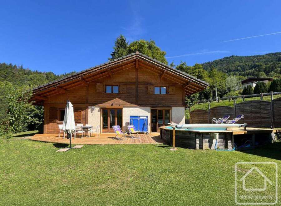 Discover your dream alpine retreat! This stunning property boasts a charming wooden exterior, a spacious deck perfect for entertaining, and a refreshing pool for those warm summer days.