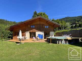 Discover your dream alpine retreat! This stunning property boasts a charming wooden exterior, a spacious deck perfect for entertaining, and a refreshing pool for those warm summer days.