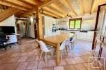 This stunning property boasts a spacious dining area with a large wooden table and stylish white chairs, perfect for entertaining.