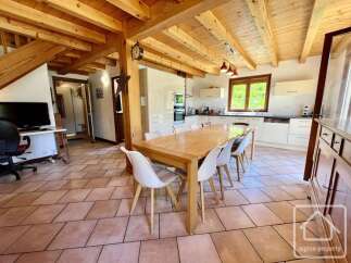 This stunning property boasts a spacious dining area with a large wooden table and stylish white chairs, perfect for entertaining.