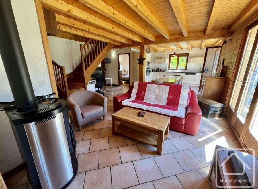 Discover the charm of this inviting living space, featuring a cozy red sofa and a stylish wooden coffee table.