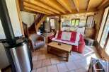 Discover the charm of this inviting living space, featuring a cozy red sofa and a stylish wooden coffee table.