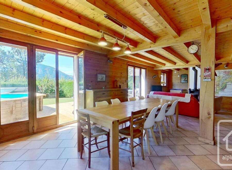 Experience the charm of this stunning property, featuring a spacious dining area with a large wooden table, perfect for gatherings.