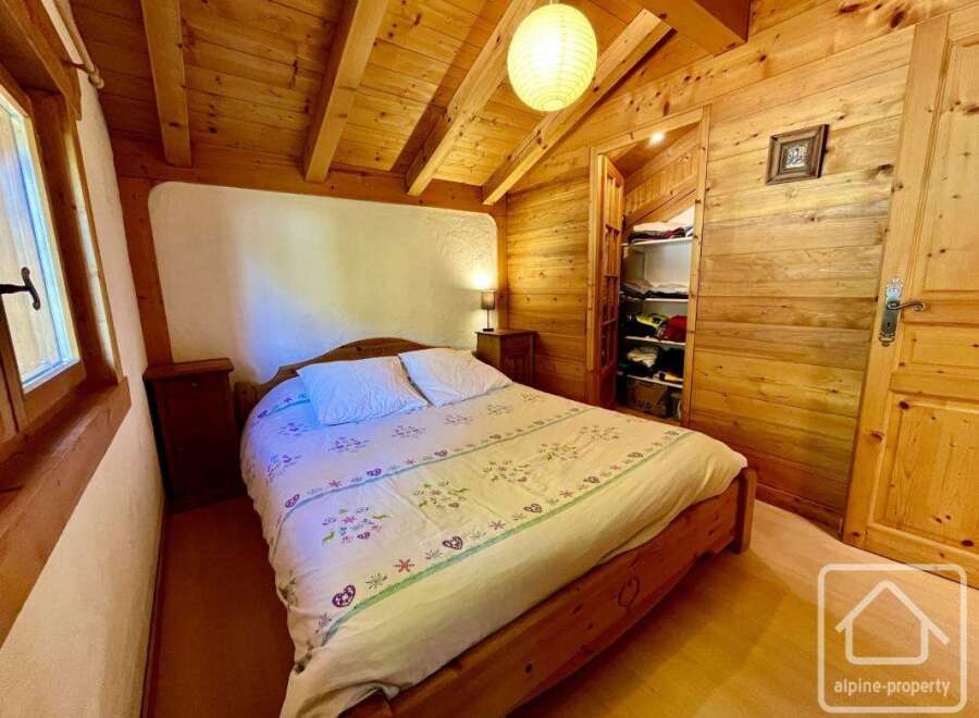This cozy bedroom features a wooden bed frame and a charming floral duvet cover, creating a warm and inviting atmosphere.
