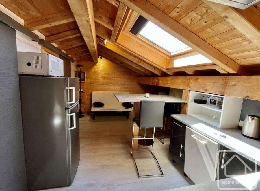 Discover the charm of this cozy apartment, featuring a unique wooden ceiling and a well-equipped kitchenette.
