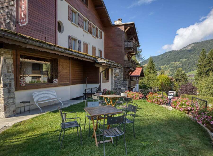 Nestled in a picturesque setting, this charming property boasts a traditional alpine design with wooden accents and a welcoming outdoor area.