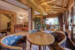 This cozy interior features a charming seating area with round wooden tables and patterned chairs, perfect for intimate gatherings.