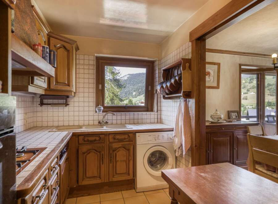 This charming kitchen boasts classic wooden cabinetry and a cozy atmosphere, perfect for preparing meals.