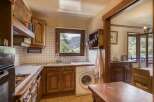 This charming kitchen boasts classic wooden cabinetry and a cozy atmosphere, perfect for preparing meals.