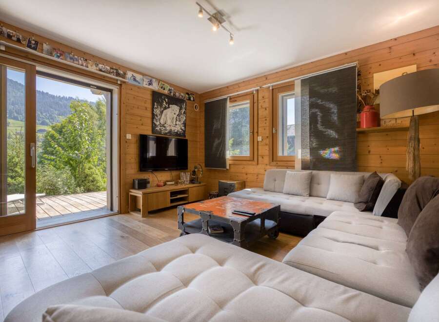 This cozy living room features a stunning view of the surrounding nature through a large sliding door.