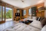 This cozy living room features a stunning view of the surrounding nature through a large sliding door.